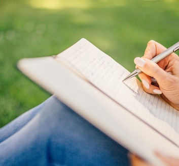 Stylized Photo of Someone Writing in a Journal